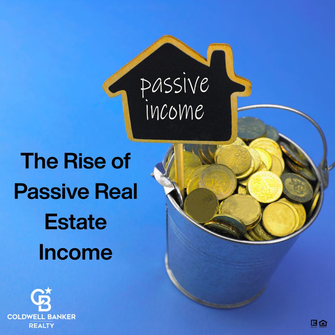 A small metal bucket filled with gold coins sits on a blue background. A miniature house-shaped chalkboard sign labeled “Passive Income” is placed in the bucket. Text on the left reads “The Rise of Passive Real Estate Income,” alongside the Coldwell Banker Realty logo.