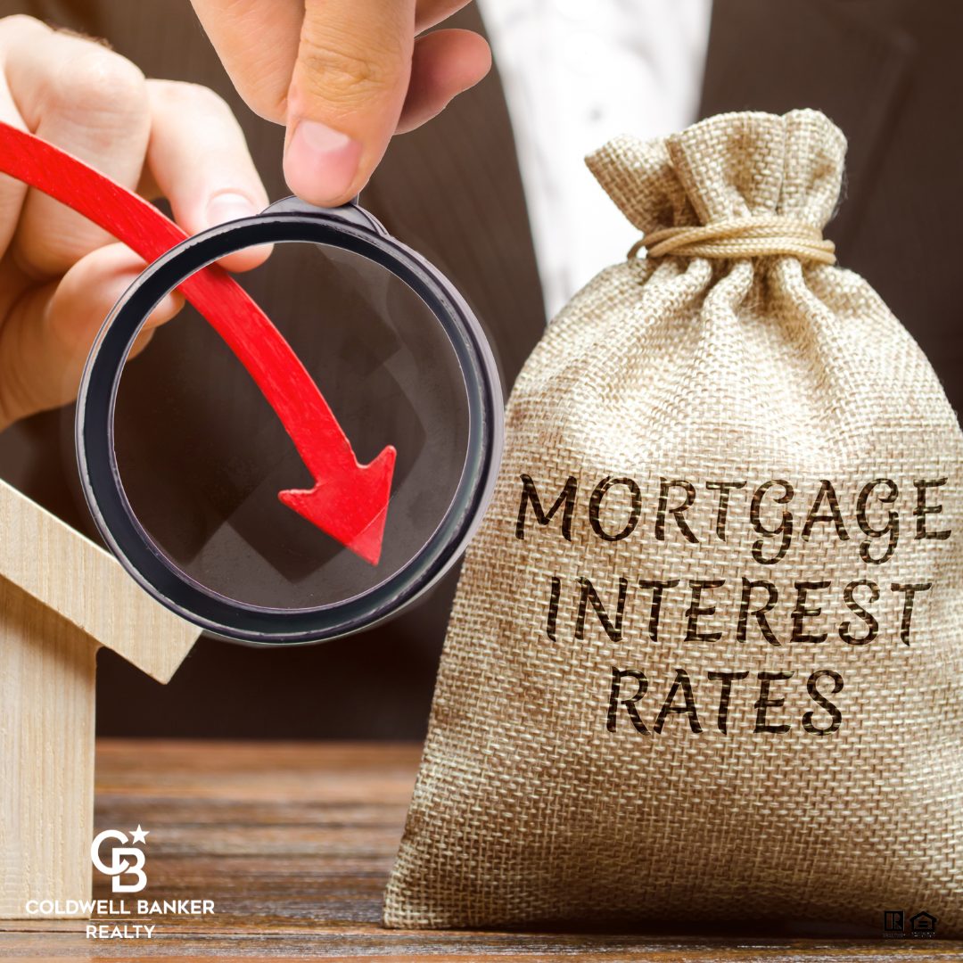 A businessperson examines a downward red arrow through a magnifying glass next to a burlap bag labeled “Mortgage Interest Rates,” symbolizing decreasing mortgage rates and greater home affordability.