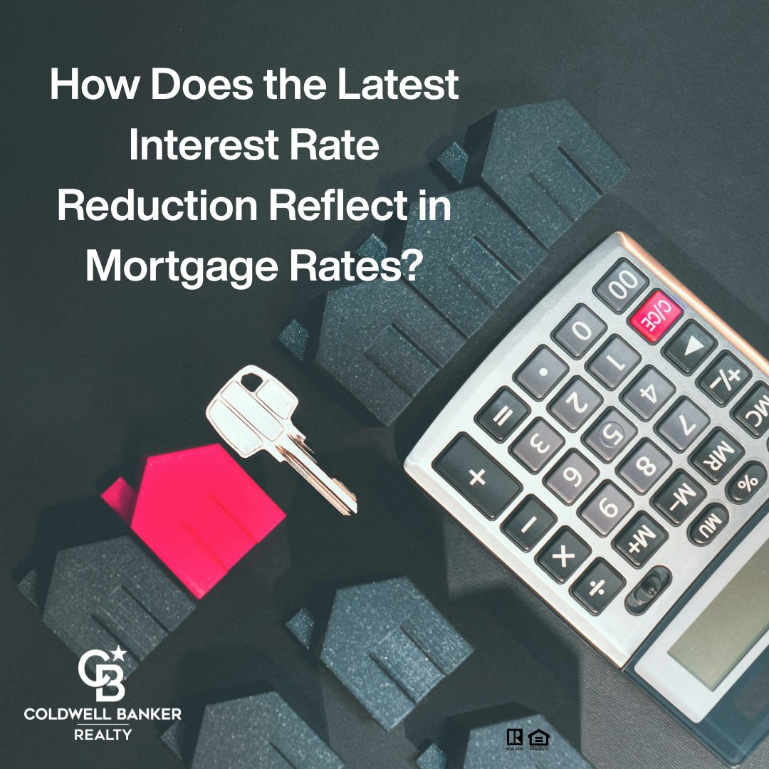 Flat lay of a house-shaped board, calculator, and house key with text asking how the latest interest rate reduction affects mortgage rates. Coldwell Banker Realty branding displayed