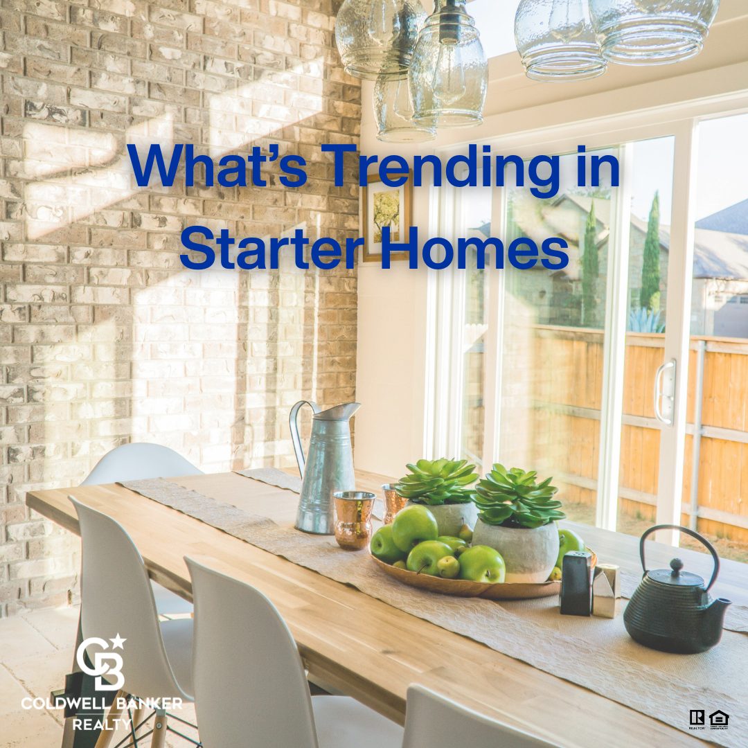 A bright, modern dining area with natural light, brick accent wall, wood table, and fresh green decor promoting a real estate blog titled “What’s Trending in Starter Homes” by Coldwell Banker Realty.