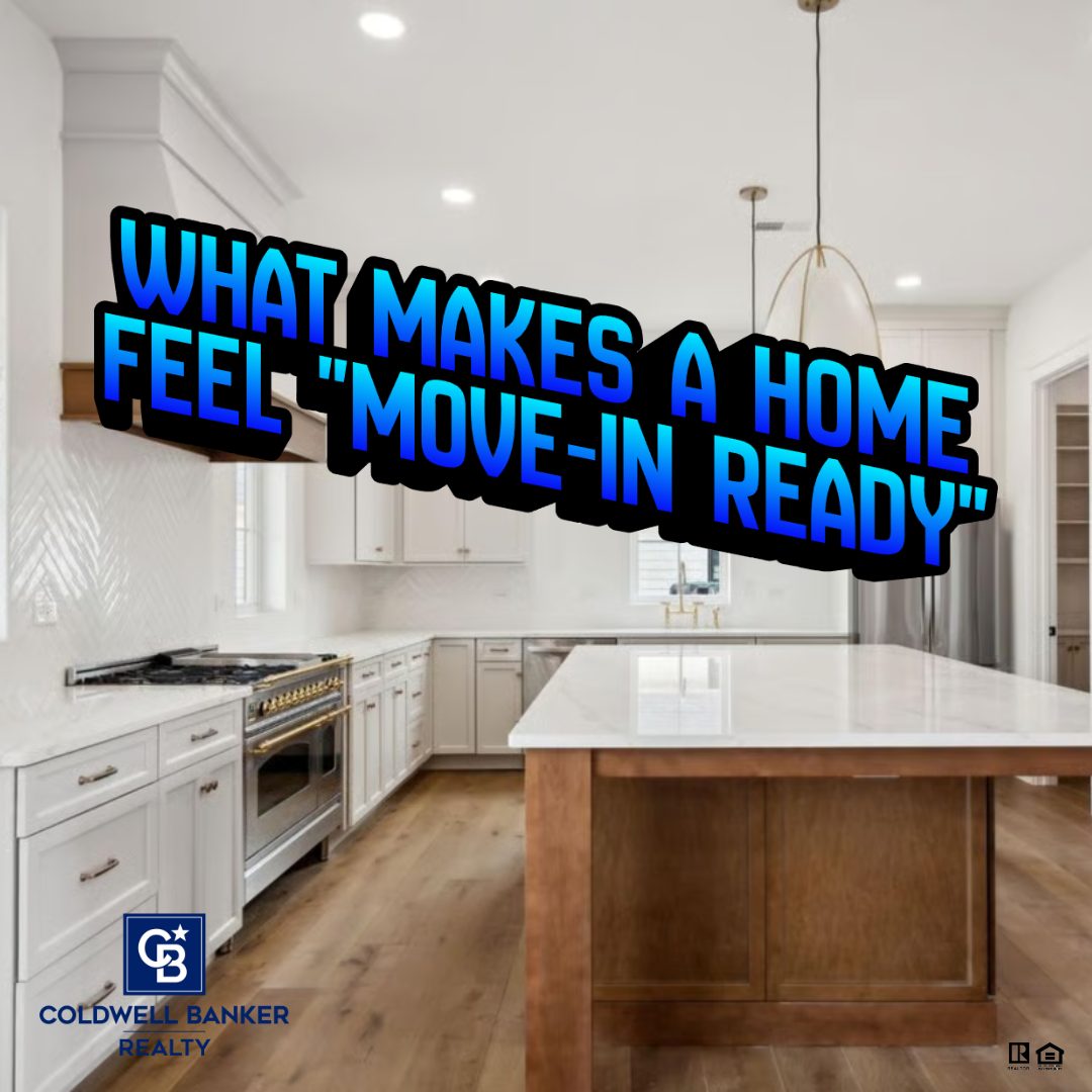 Bright, move-in ready kitchen with white cabinetry, large island, modern lighting, and wood floors, featuring text overlay asking what makes a home feel move-in ready.
